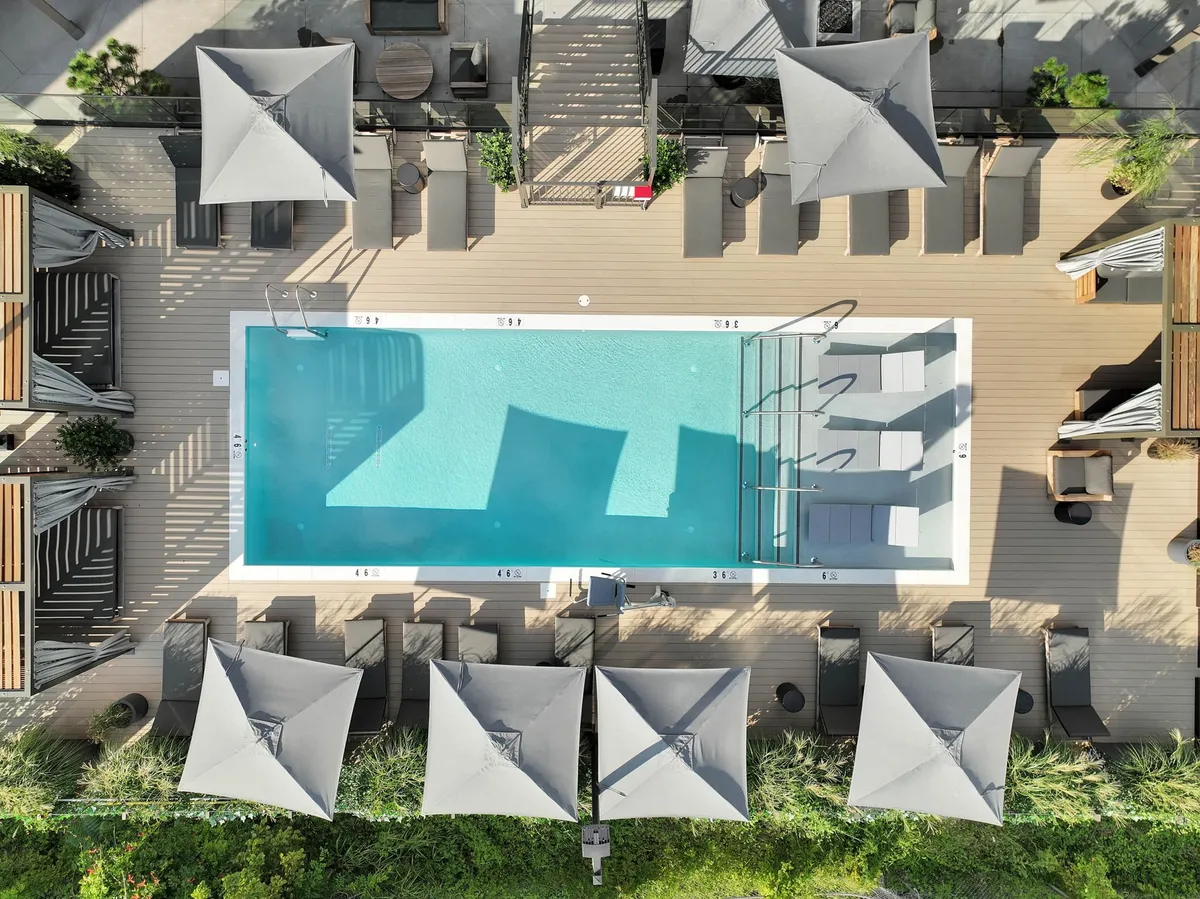 A serene resort-style pool with lounge chairs and umbrellas, perfect for unwinding after a night out. The tranquil setting offers a relaxing contrast to the city’s energy, connecting the excitement of exploration with moments of retreat back at the property.