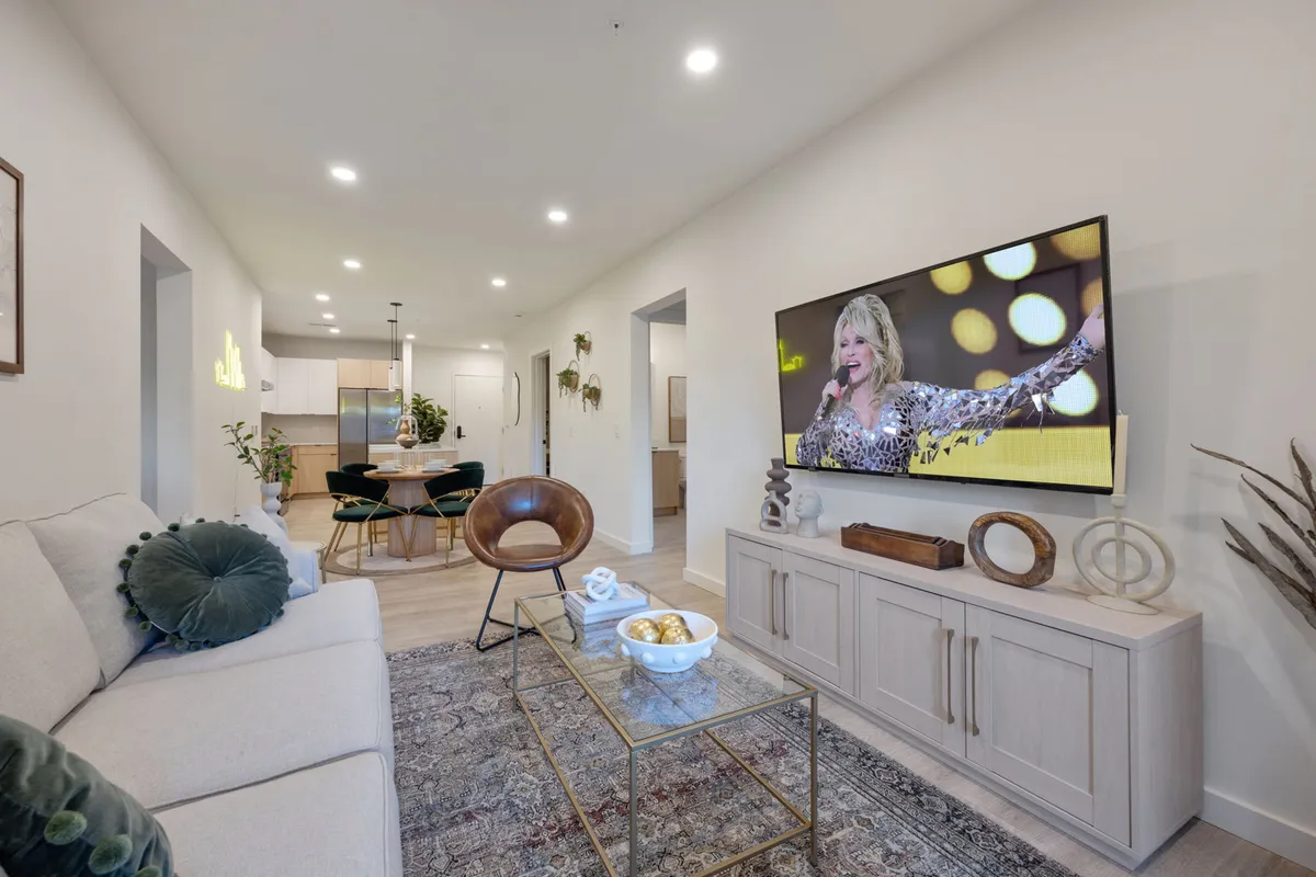 A modern, open-concept living and dining area featuring a comfortable sofa, a coffee table, and a dining table. The space feels inviting and flexible, ideal for families or groups to gather, relax, and enjoy shared moments. There’s clear evidence of thoughtful touches and a professional standard of cleanliness and organization.
